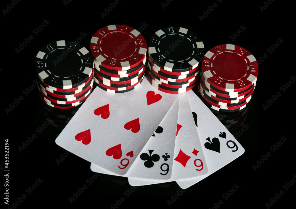 Obraz premium Poker game with four of kind combination. Chips and cards on the black table. Successful and maximum win