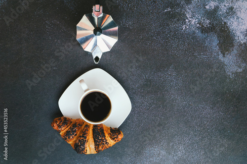 Businessman working morning with notebook, cup of hot coffee and sweet croissant on black background. Top view, copy space, mockup. Flat lay. Modern breakfast food.