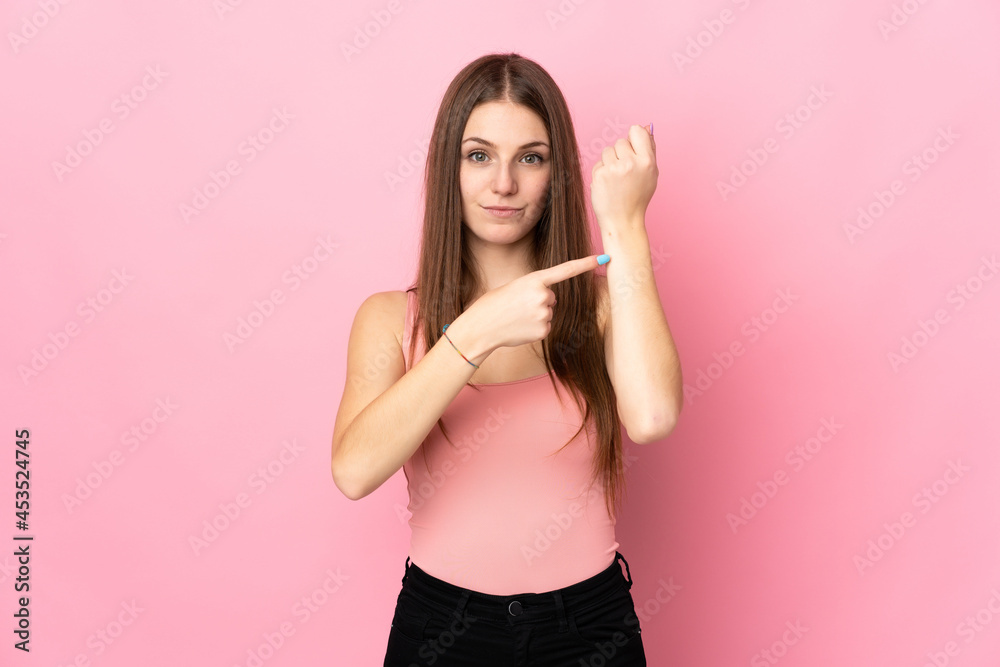 Young caucasian woman isolated on pink background making the gesture of being late Young caucasian woman isolated on pink background making the gesture of being late