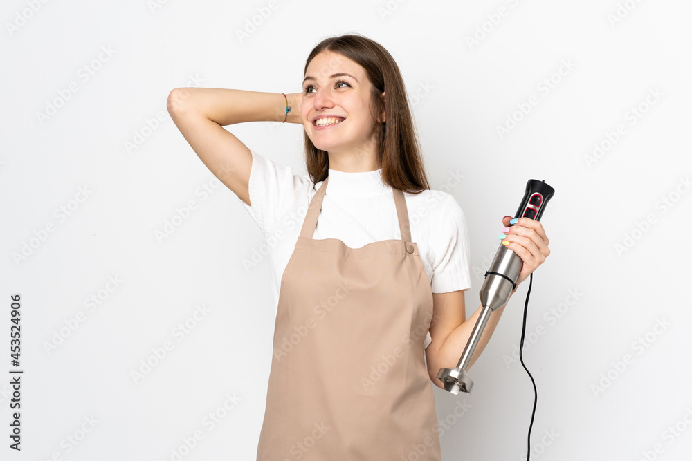 Young woman using hand blender isolated on white background laughing Young woman using hand blender isolated on white background laughing