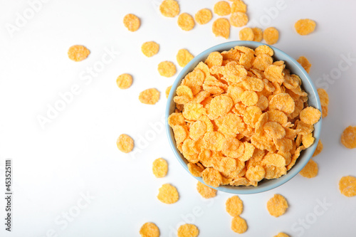 Delicious cornflakes in a plate on a light background.