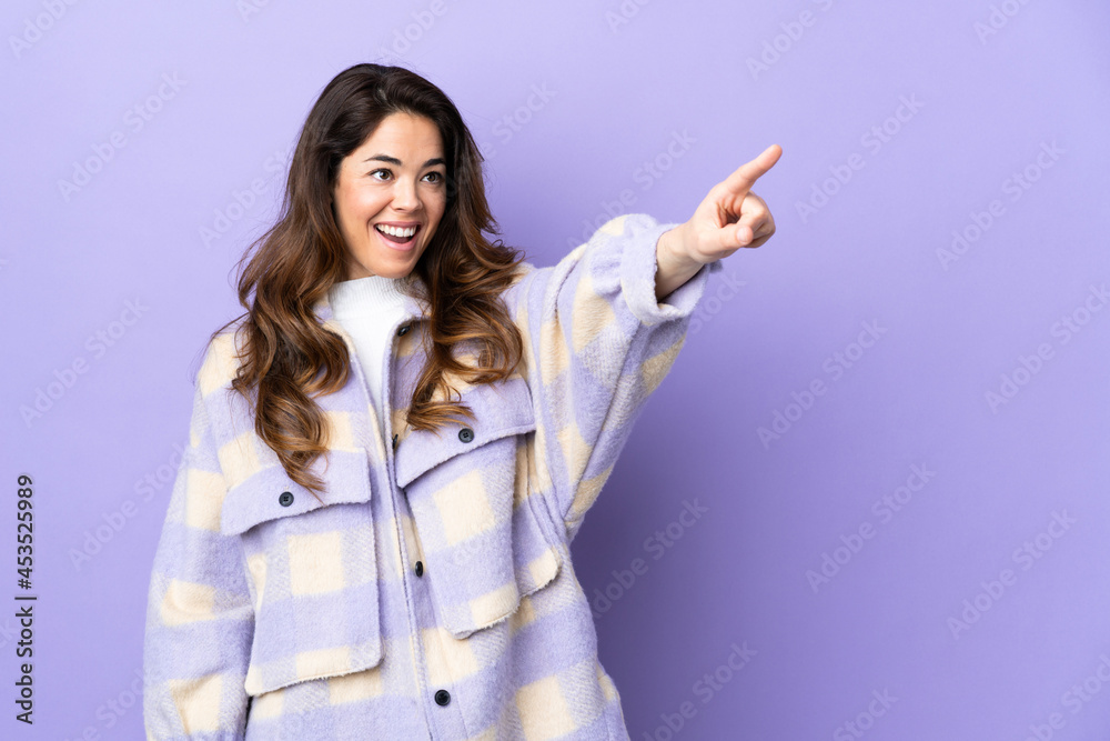 Woman over isolated purple background pointing away Woman over isolated purple background pointing away