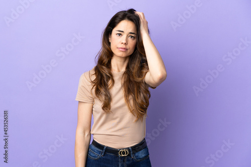 Woman over isolated purple background with an expression of frustration and not understanding