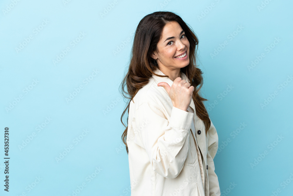 Woman over isolated background pointing to the side to present a product Woman over isolated background pointing to the side to present a product