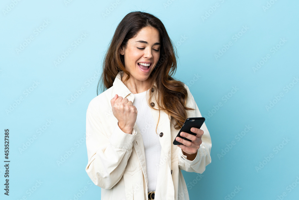 Woman over isolated background with phone in victory position Woman over isolated background with phone in victory position