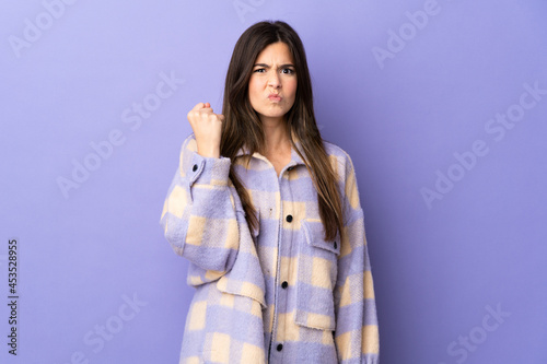 Teenager Brazilian girl over isolated purple background with unhappy expression © luismolinero