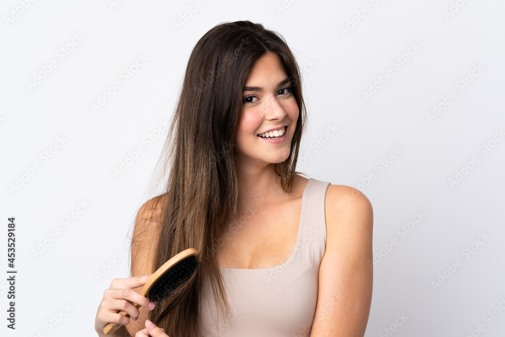Teenager Brazilian girl with hair comb over isolated background Teenager Brazilian girl with hair comb over isolated background