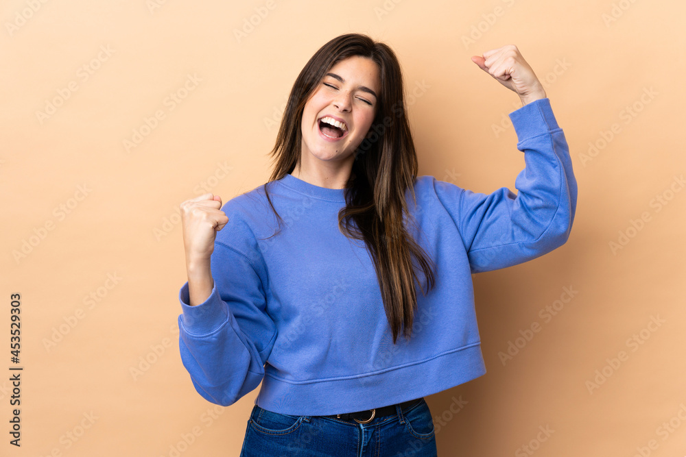 Teenager Brazilian girl over isolated background celebrating a victory Teenager Brazilian girl over isolated background celebrating a victory