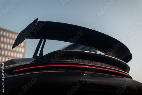 Big carbon spoiler wing on the trunk of modern supercar photo