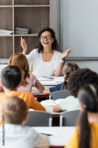 excited african american teacher showing wow gesture during lesson
