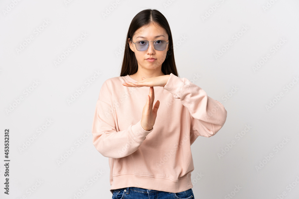 Young Chinese girl over isolated white background making time out gesture