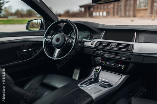 Modern car interior with the leather panel, and dashboard at the city center © Moose