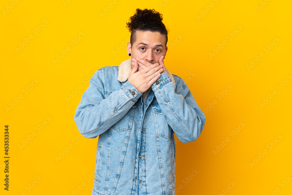 Fototapeta premium Caucasian man over isolated background covering mouth with hands