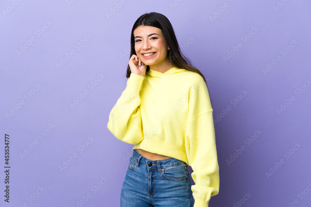 Young brunette woman over isolated purple background laughing