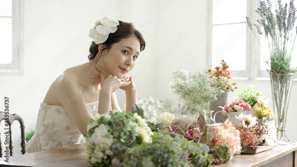 花束の前でリラックスするウエディングドレスを着た女性 Stock Photo Adobe Stock