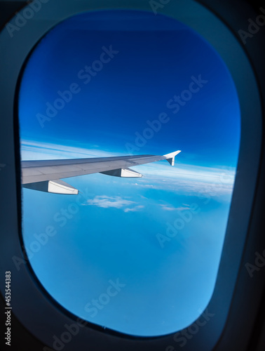 View from an airplane window above the clouds When sitting next to the engine of the plane will see the beauty of the sky on holiday.