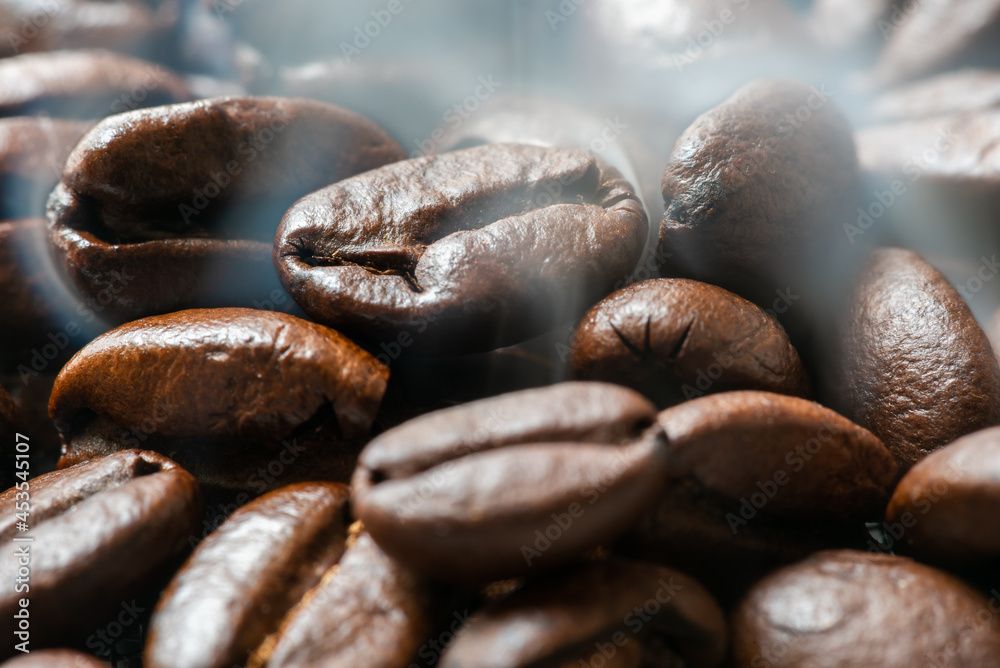 Heap of roasted coffee beans close-up view with smoke Heap of roasted coffee beans close-up view with smoke