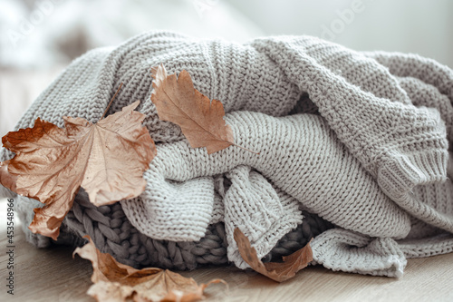 Autumn background with knitted sweaters close up.