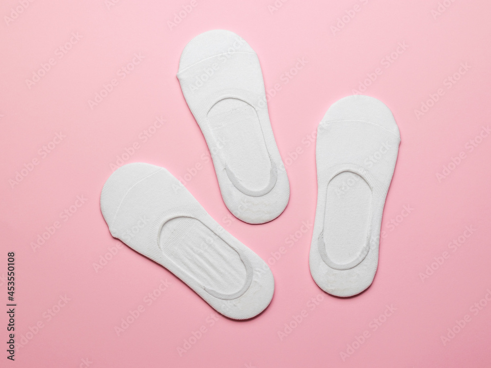 White women's socks on a pink background. Flat lay. White women's socks on a pink background. Flat lay.