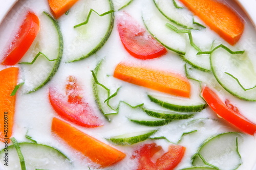 Bowl of delicious and healthy vegan diet food- organic cucumber, carrot, onion, tomato salad with curd, 