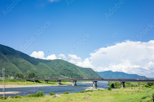 summer scenery of blue sky with clouds, mountain range, and brige over the chikuma river in nagano prefecture, japan photo