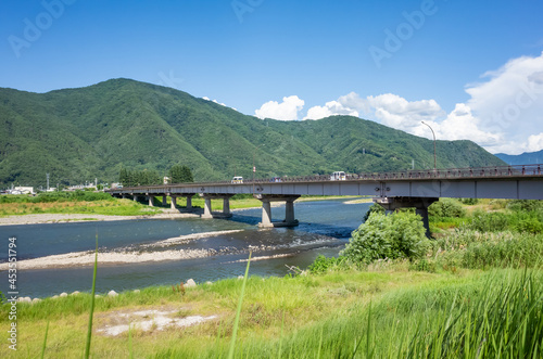 summer scenery of blue sky with clouds, mountain range, and brige over the chikuma river in nagano prefecture, japan photo