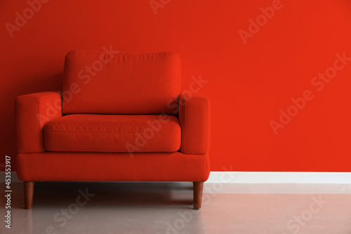 Comfortable armchair near red wall