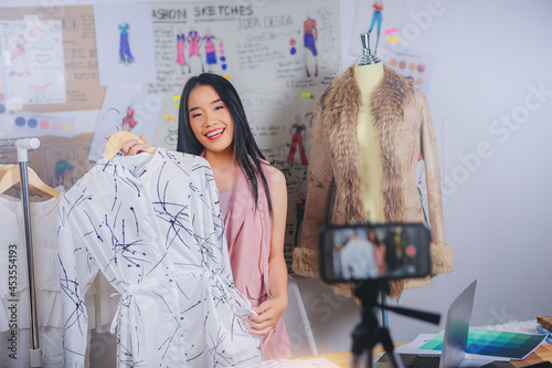 Fashion designer stylish woman working on her online marketing, selling live stream in the studio. photo