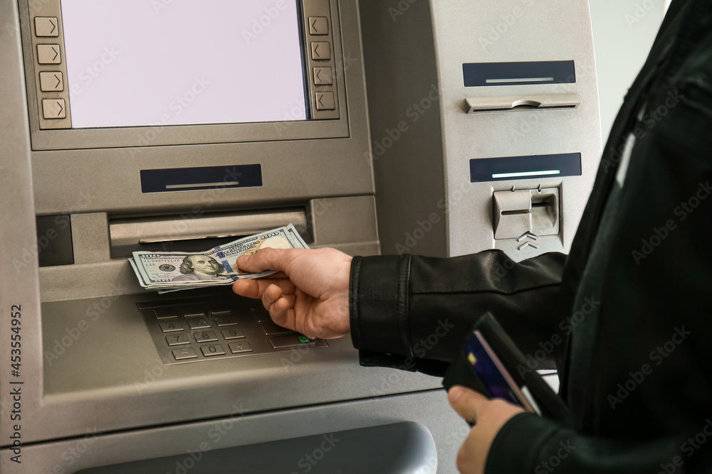Man withdrawing money from ATM Man withdrawing money from ATM