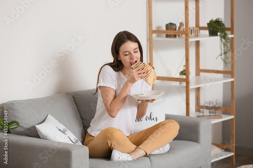Beautiful young woman eatin...