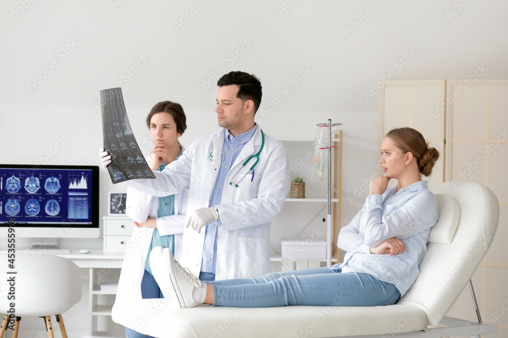 Young doctors with x-ray image of spine in clinic Young doctors with x-ray image of spine in clinic