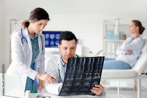 Young doctors with x-ray image of spine in clinic