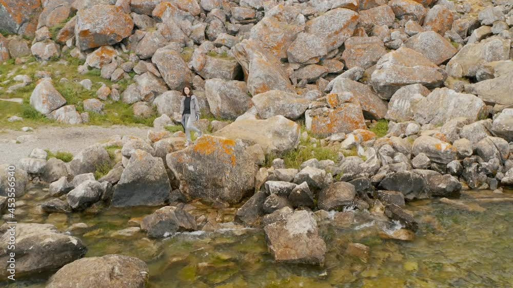Girl is standing on a granite stones Summer Baikal lake Olkhon island Girl is standing on a granite stones Summer Baikal lake Olkhon island