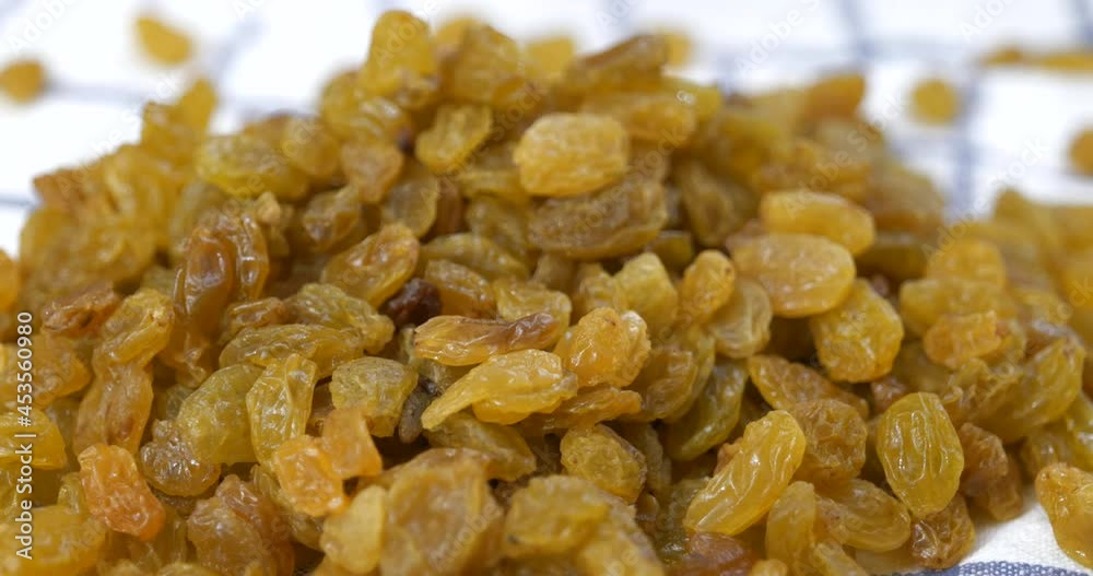 Golden raisins falling onto a kitchen towel Golden raisins falling onto a kitchen towel
