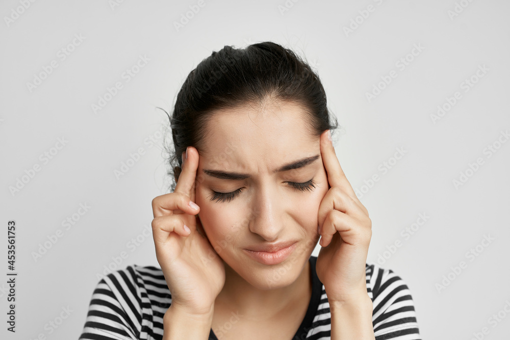 sick woman in a striped t-shirt pain in the neck light background sick woman in a striped t-shirt pain in the neck light background