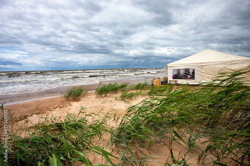 Beach Cafe tent on stormy sea shore © Ints
