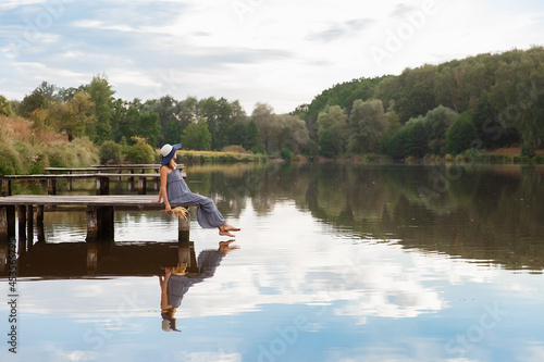 girl in a hat on a wooden bridge