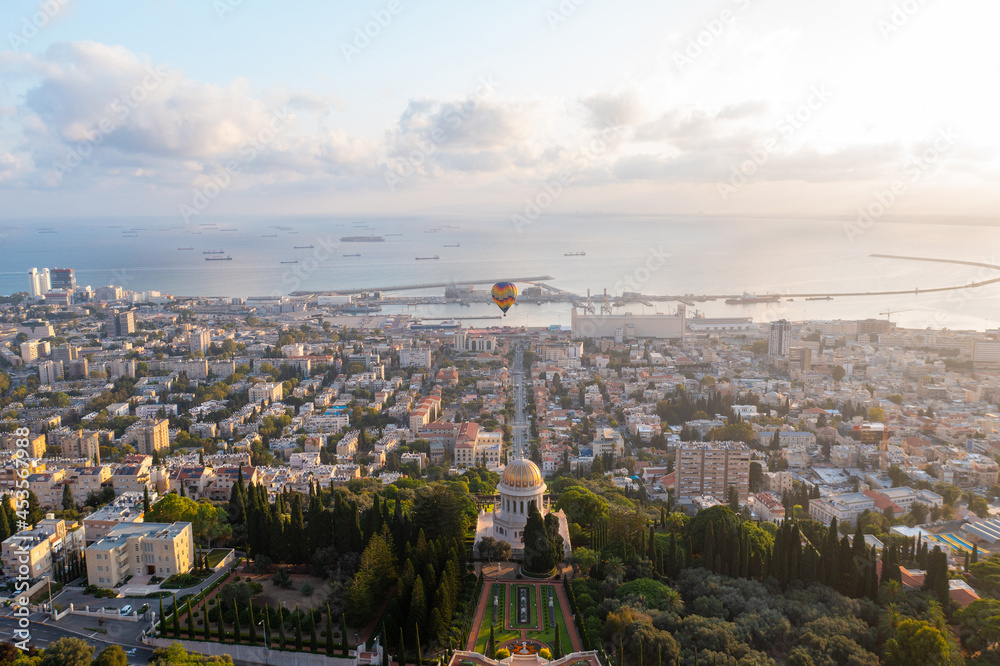 Hot air balloon above the Bahai temple and gardens and Downtown Haifa at sunrise, Aerial view.