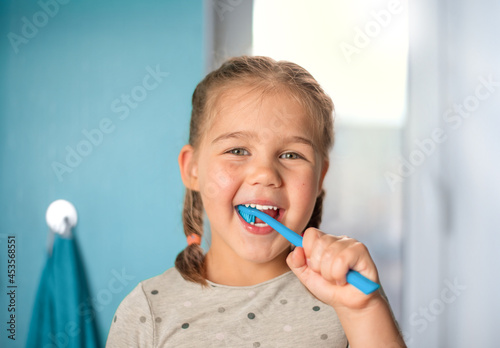 little girl brushing teeth in the bathroom