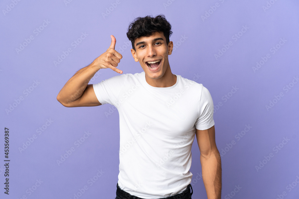 Young Argentinian man isolated on background making phone gesture. Call me back sign