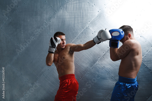 Two men boxers fighting muay thai boxing. © primipil