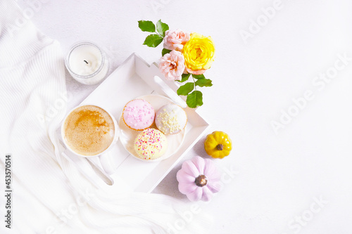 Cup of coffee  pink pumpkins  roses bouquet  cupcakes on the white background. Feminine atmosphere. Woman power. Happy Halloween. Girlish fall composition. Coffee break at home. Holiday girly concept.
