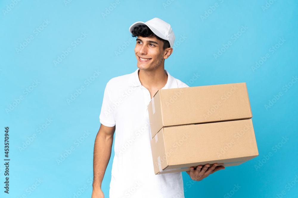 Delivery Argentinian man isolated on blue background thinking an idea while looking up Delivery Argentinian man isolated on blue background thinking an idea while looking up