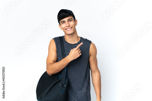 Young sport Argentinian man with sport pointing to the side to present a product