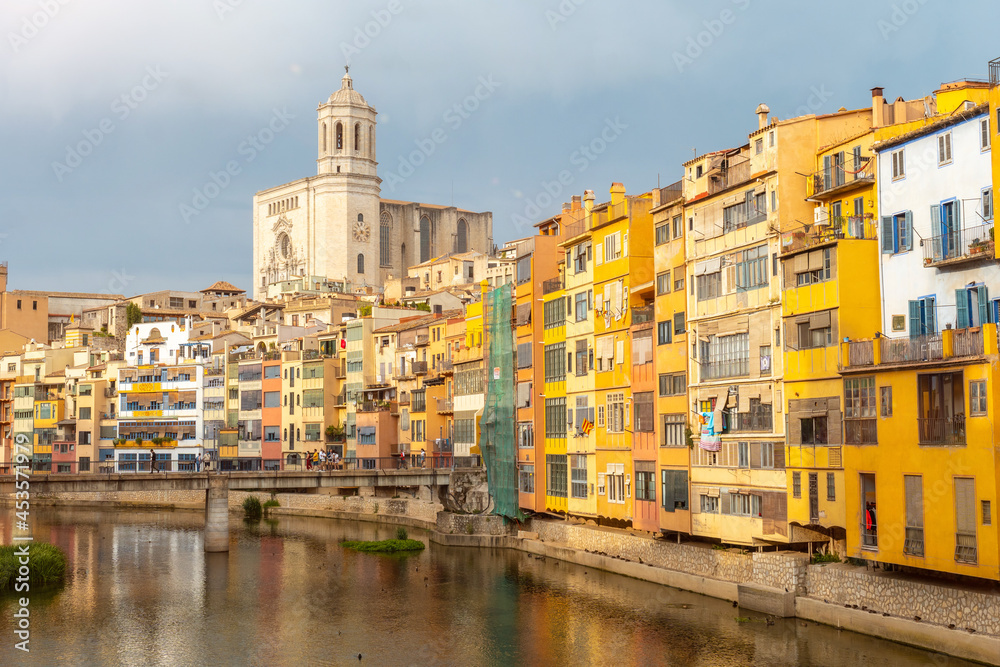 Girona medieval city, basilica and the cathedral next to the colored houses on the Onyar river, Costa Brava of Catalonia in the Mediterranean. Spain