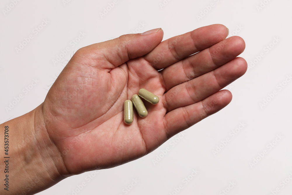 Close up of hand with 3 capsules Close up of hand with 3 capsules