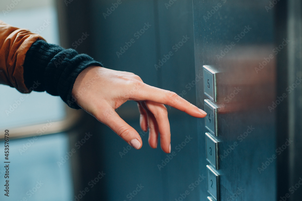 Naklejka premium Close up of forefinger pressing the button elevator during coronavirus pandemic covid-19