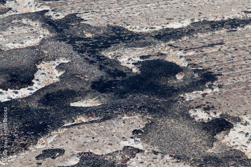 a bad asphalt road that has been repaired many times a bad asphalt road that has been repaired many times