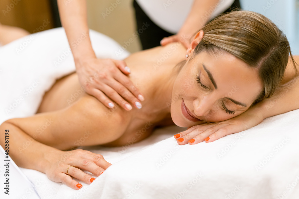 Middle-aged woman having a back massage in a beauty salon. Middle-aged woman having a back massage in a beauty salon.