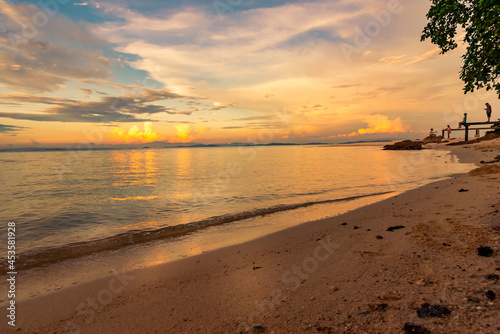 Nature in twilight period which including of sunrise over the sea and the nice beach. Summer beach with blue water and purple sky at the sunset.	
